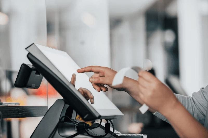 A customer tapping a card on a handheld terminal
